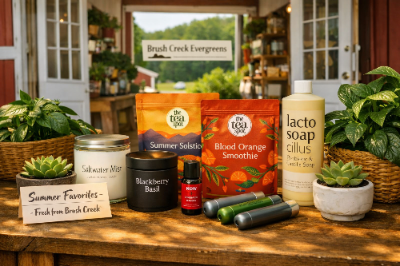 “Summer wellness and gift products displayed outdoors at Brush Creek Evergreens, including teas, soaps, candles, and succulents.”