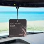 Car air freshener labeled 'Saltwater Mist' hanging from a car's rearview mirror.