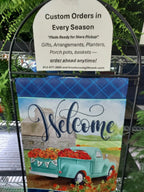 Custom order sign with small welcome flag in a black flag stand