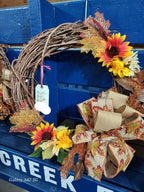 Decorative wreath with sunflowers and a bow on a blue surface